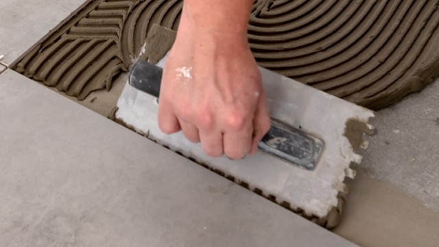 Mur&Co tiling a bathroom floor during a renovation in Copenhagen