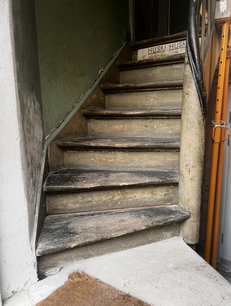 Kældertrappe med slidte trætrin før renovering udført af Mur&Co