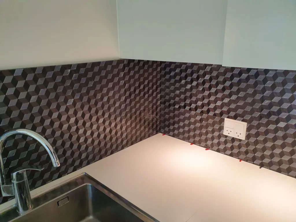 Mørke mosaikfliser over køkkenbord udført af Mur & Co ApS