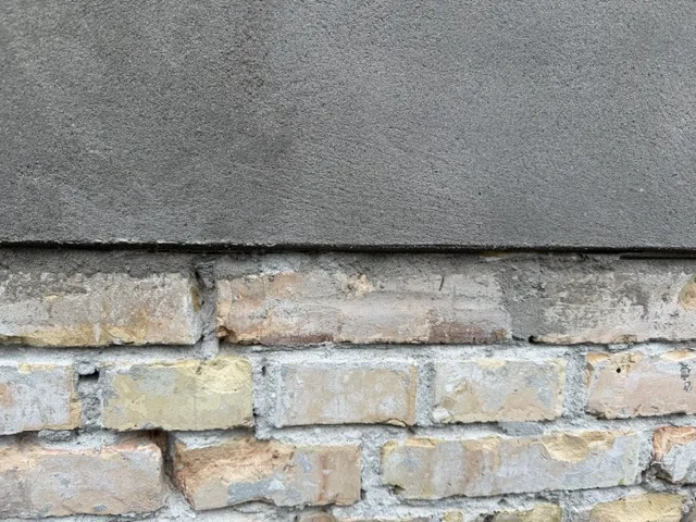 Mur&Co: nærbillede af murværk og pudset facade ved indgangsparti på Frederiksberg